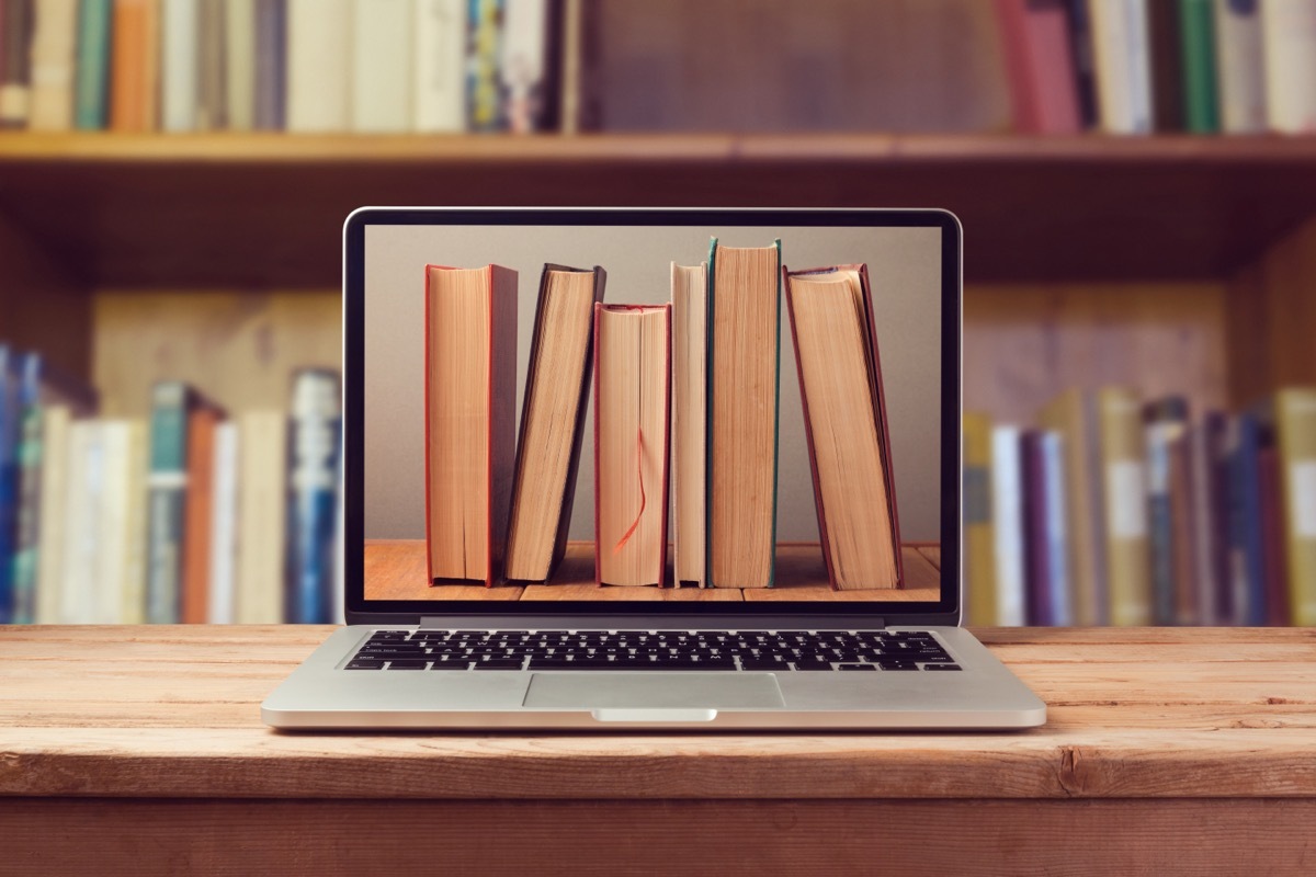 E-book library concept with laptop computer and books on monitor