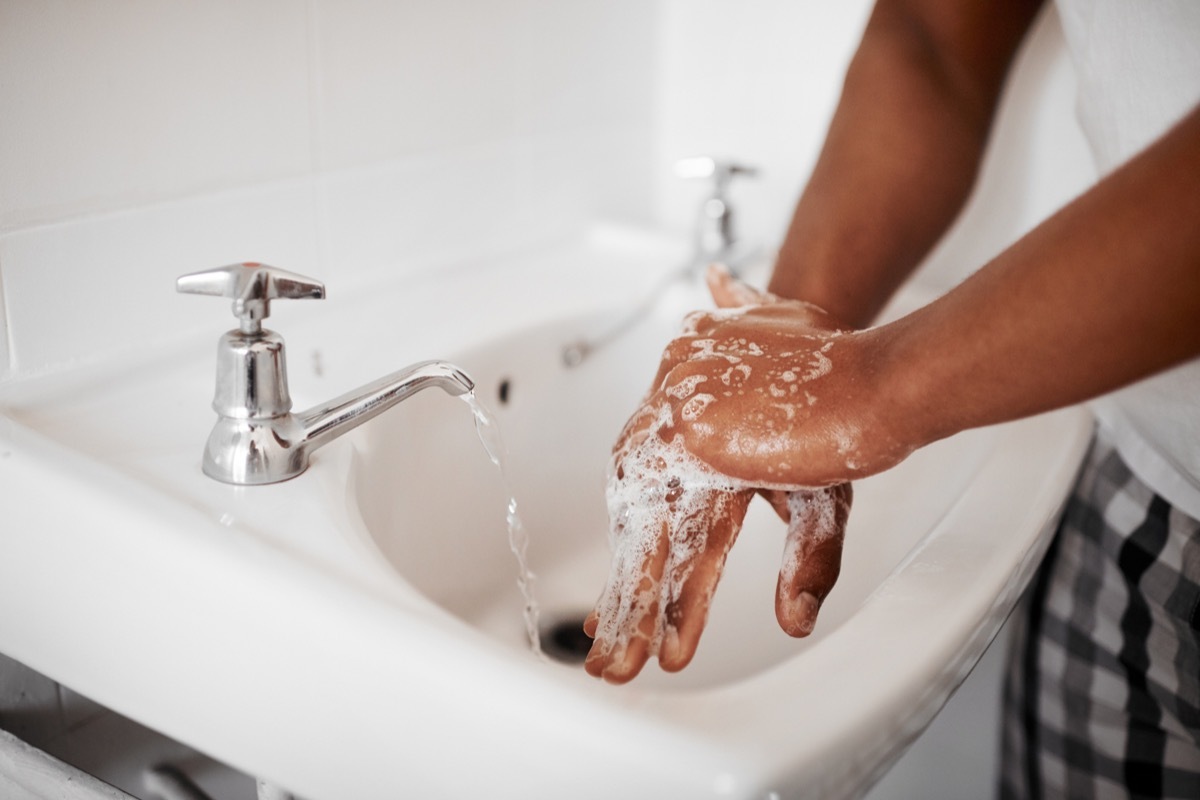 Cropped shot of an unrecognizable man washing his hands in the bathroom at home