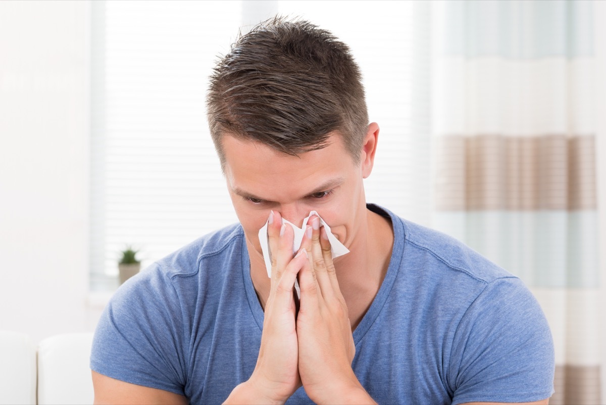 young man blowing his nose