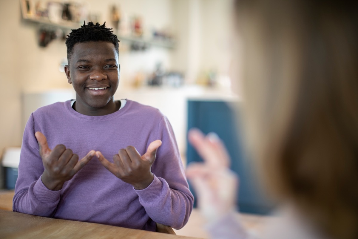 boy having a conversation in American sign language 