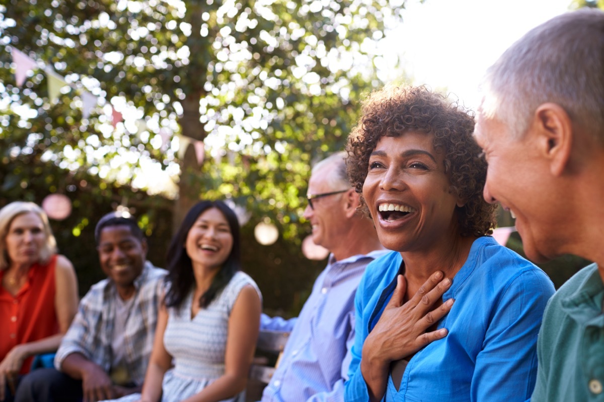 mature friends socializing In backyard