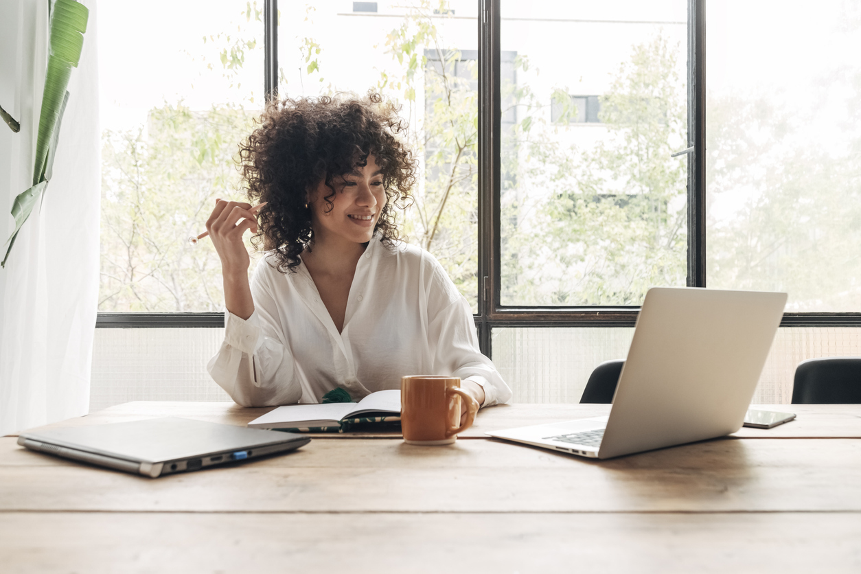 smiling young black woman writing at home