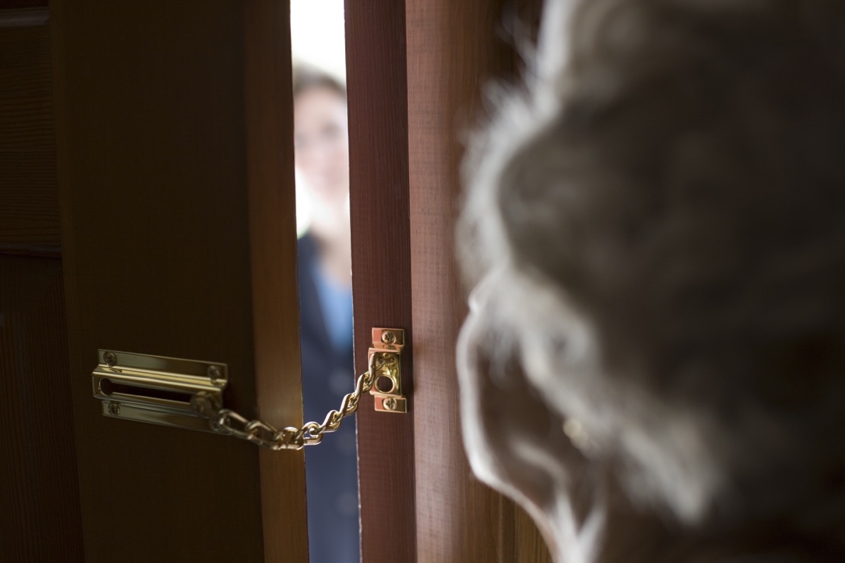 senior woman opening locked door