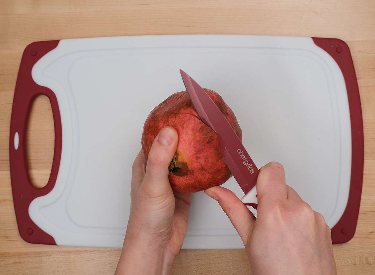 cutting the top off a pomegranate