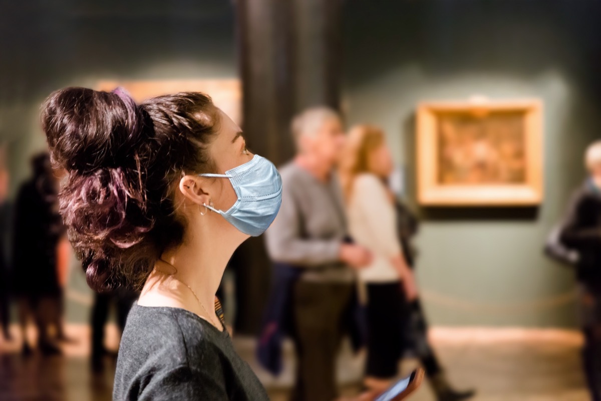 woman in a museum wearing a mask because of Covid