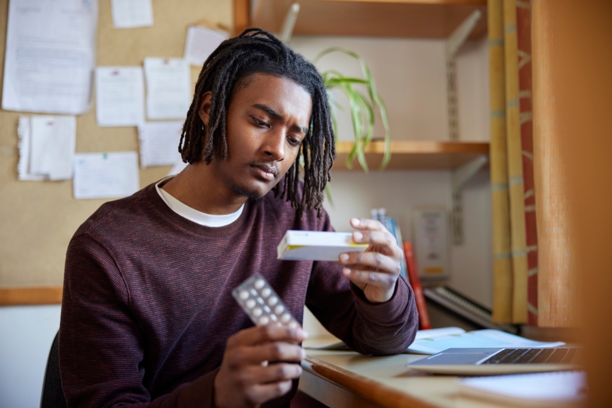 man looking at medication