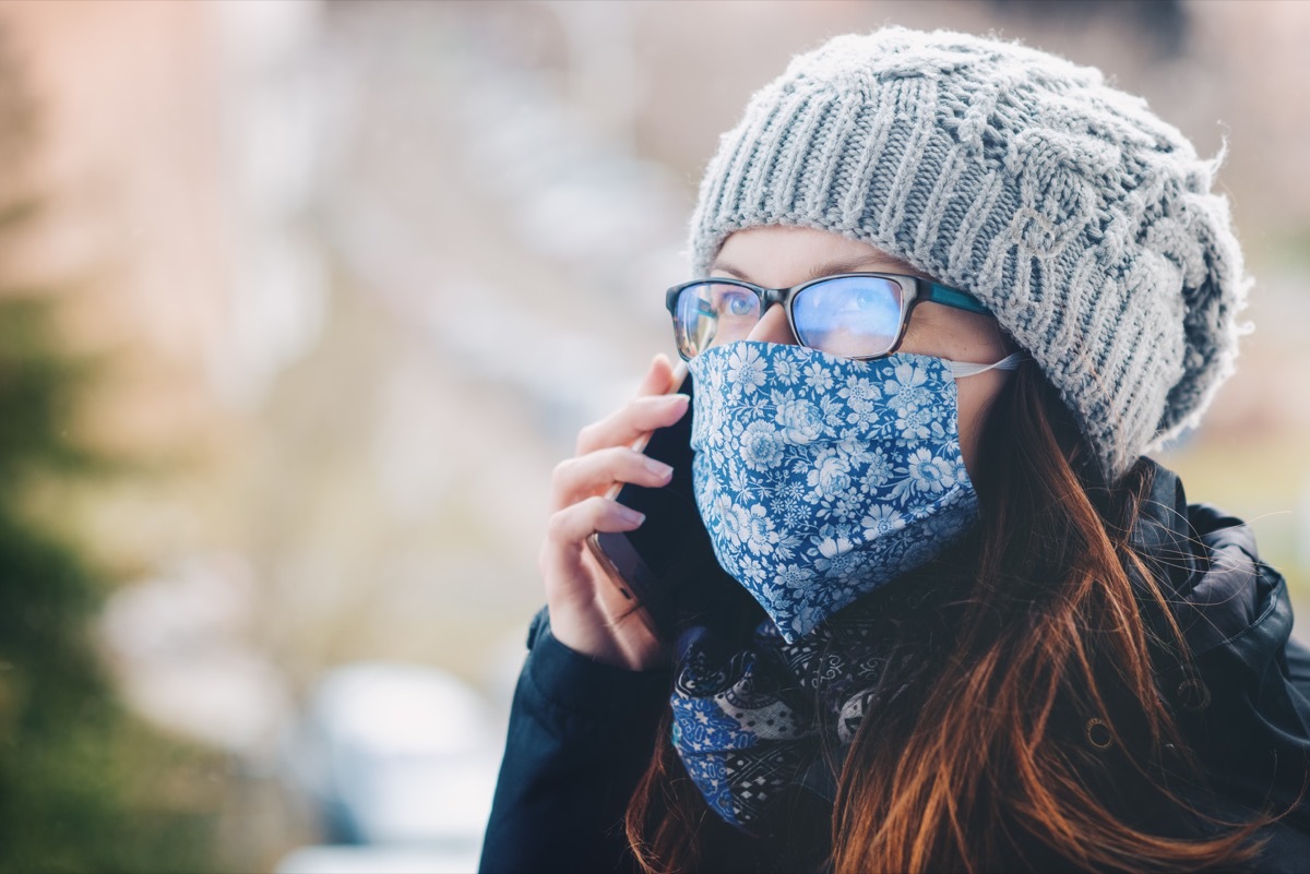 white woman on cell phone wearing cloth face mask