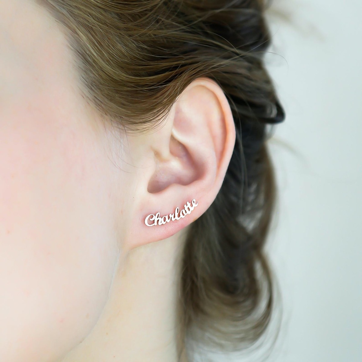 white woman with gold earring reading 