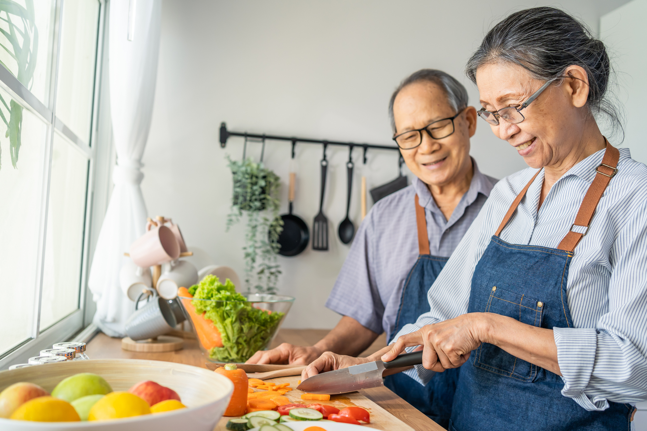 Asian senior couple cooking in kitchen