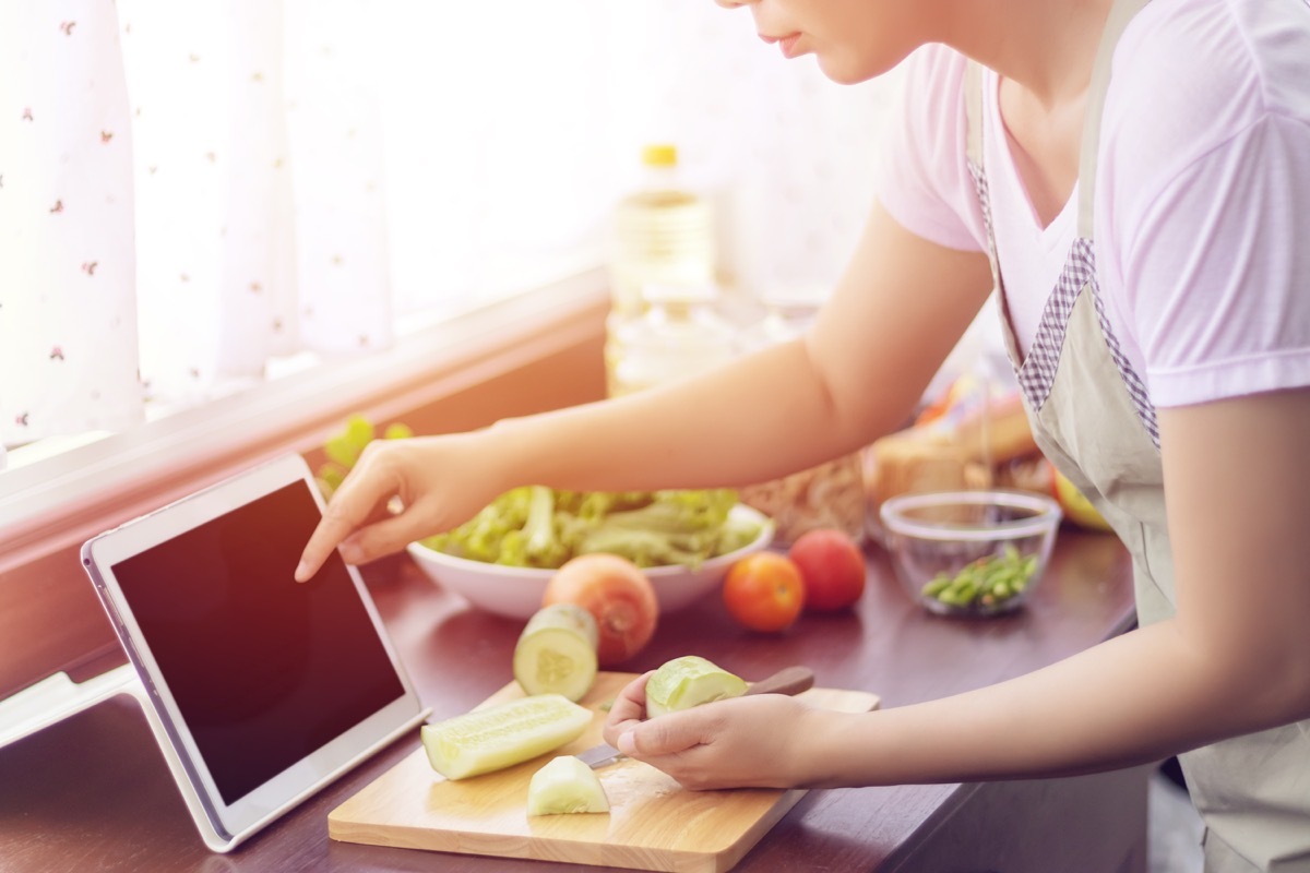 woman cooking healthy food following recipe