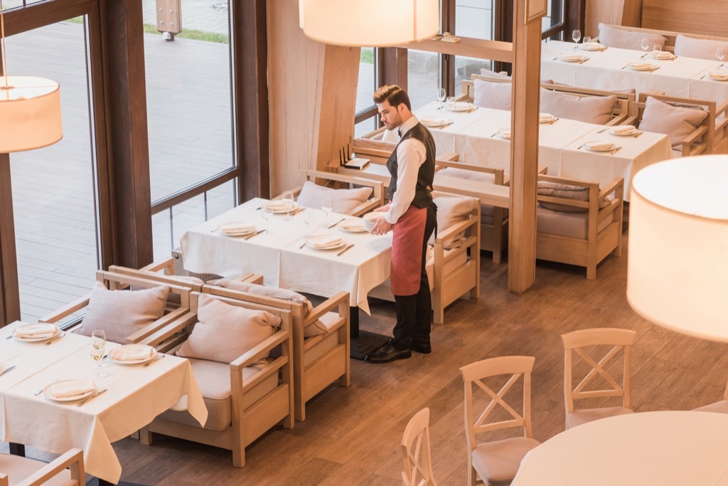 Waiter at empty restaurant Things You Should Always Do at a Fancy Restaurant