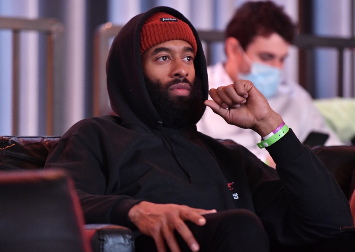 matt james watching a boxing match and wearing a beanie