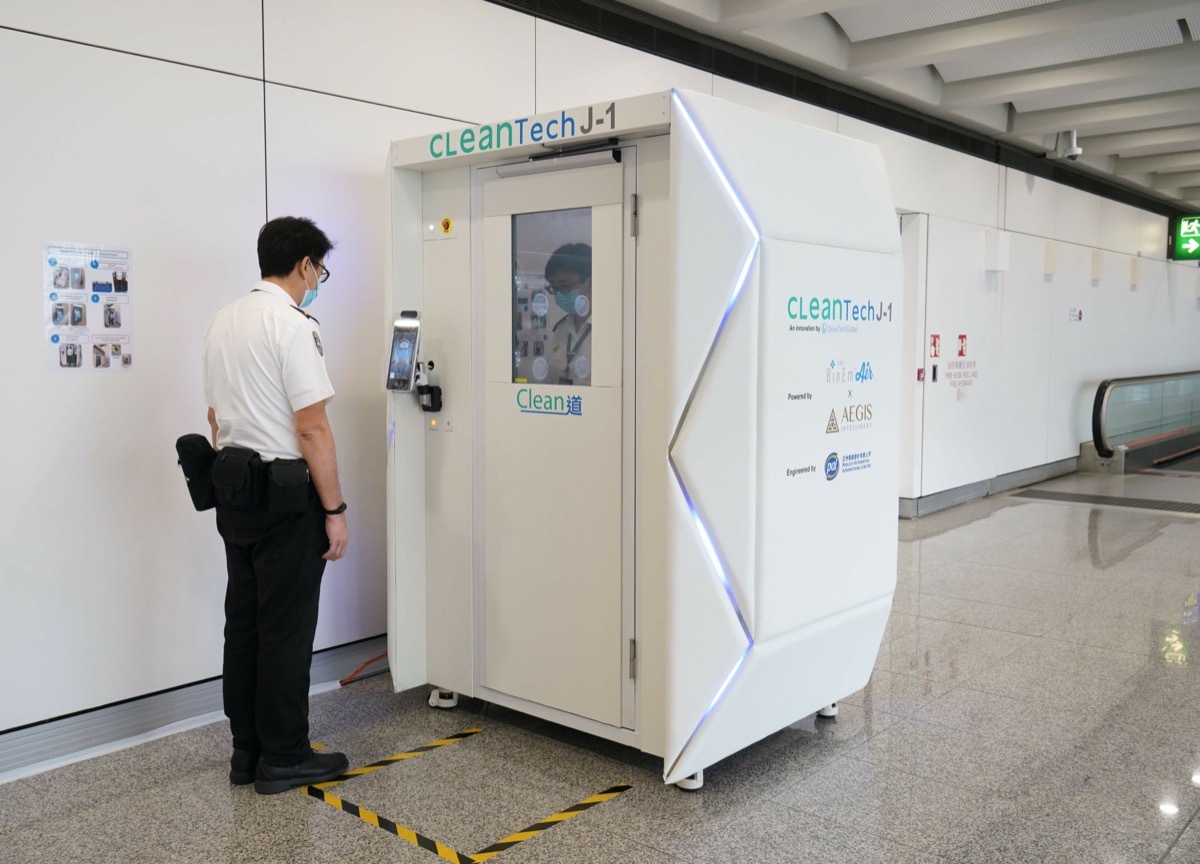 airport security steps into a health screening booth