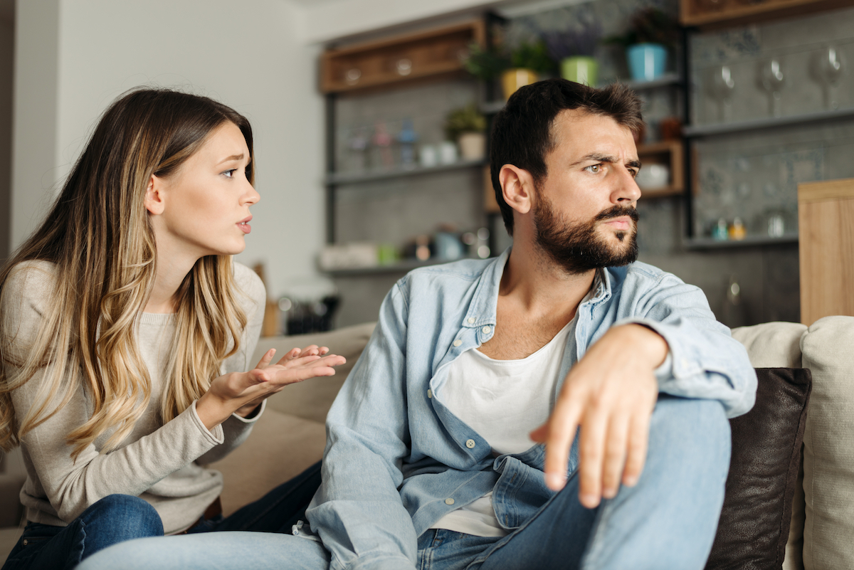 Young woman asking her boyfriend for forgiveness at home