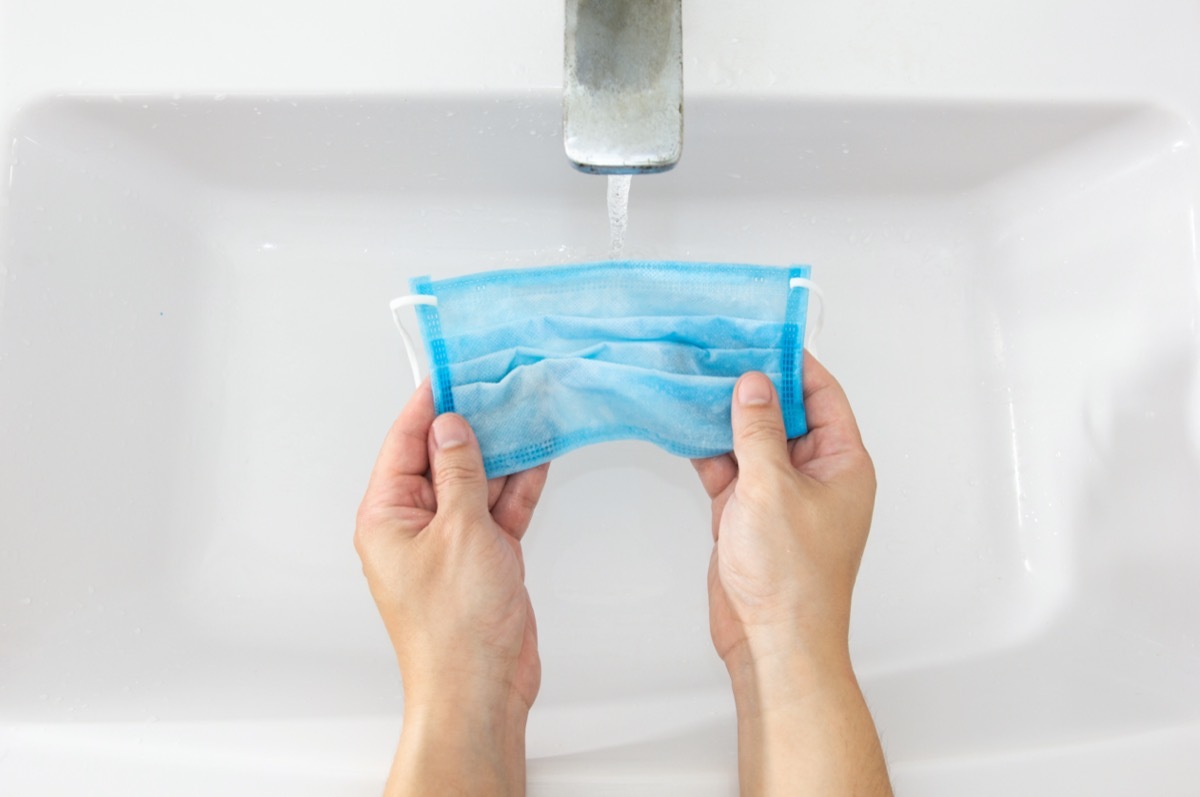 Hand of an Asian man washing a mask.