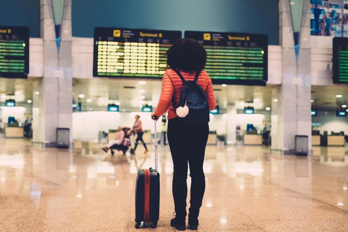 Young woman at the airport checking for the flight