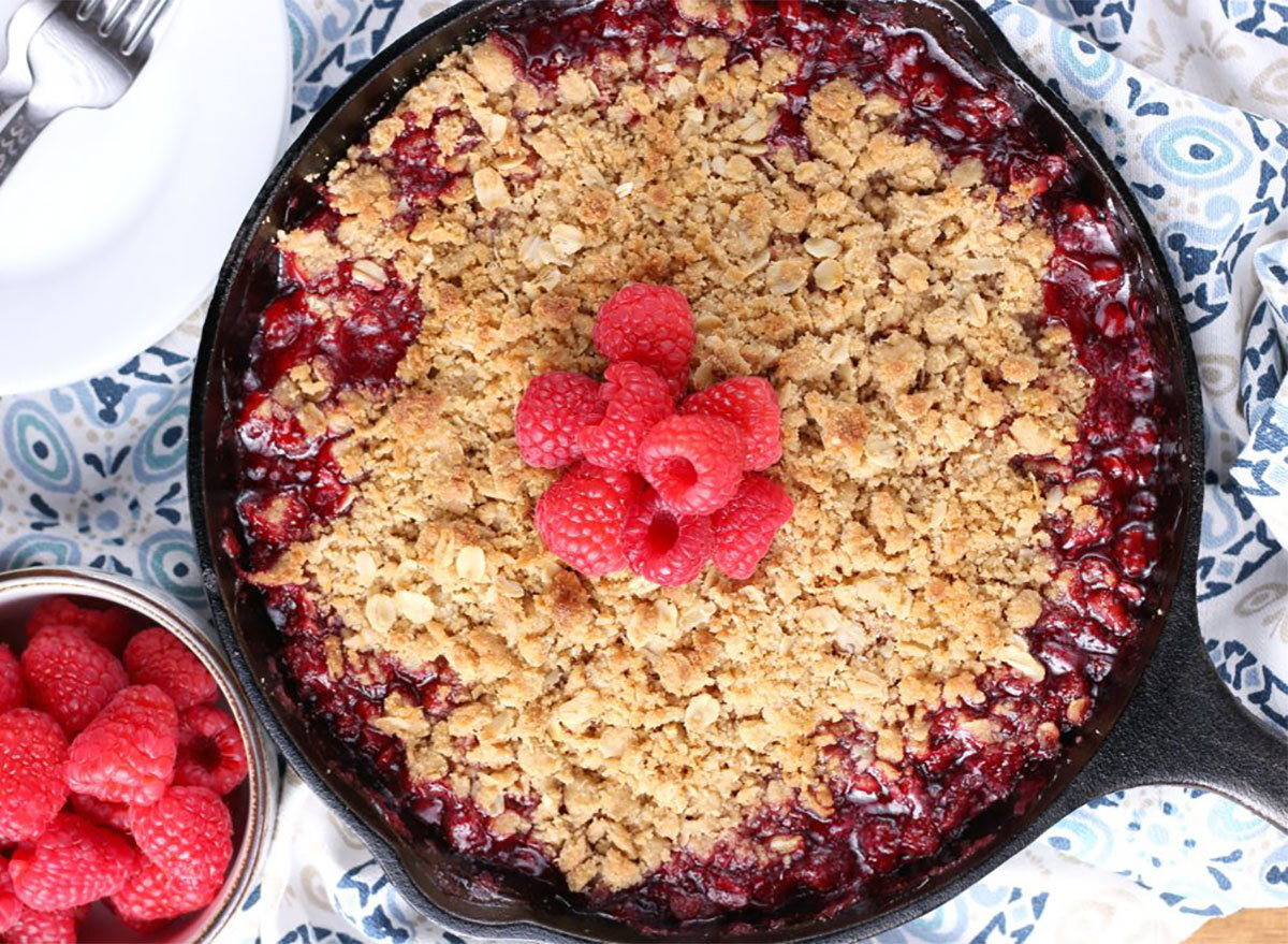 grilled skillet raspberry crisp with bowl of fresh raspberries