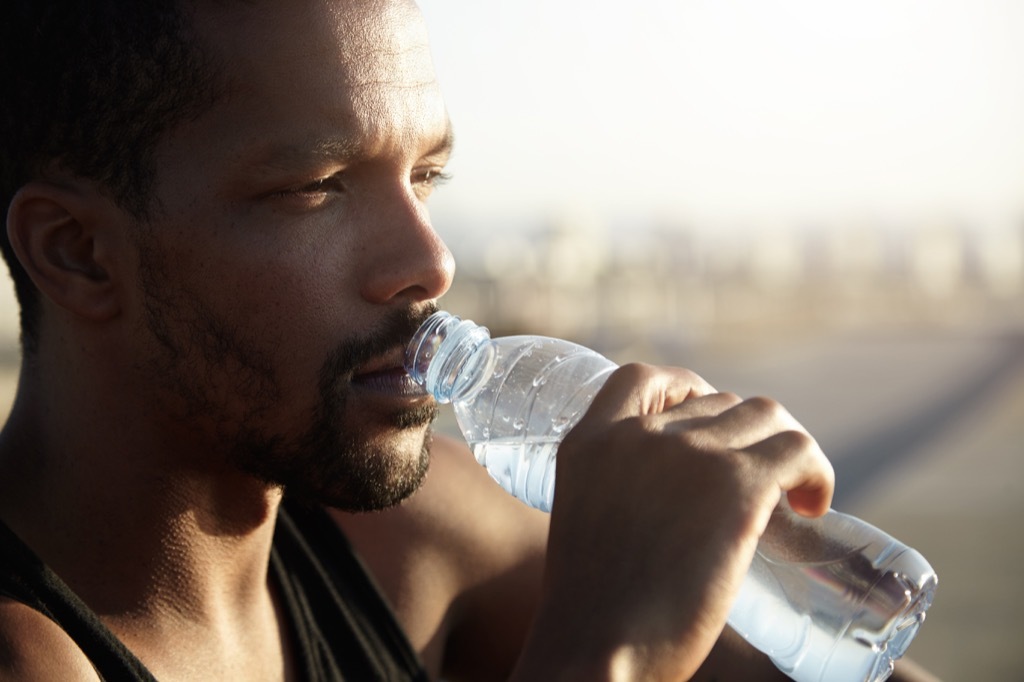 man drinking from plastic water bottle habits that increase your cancer risk