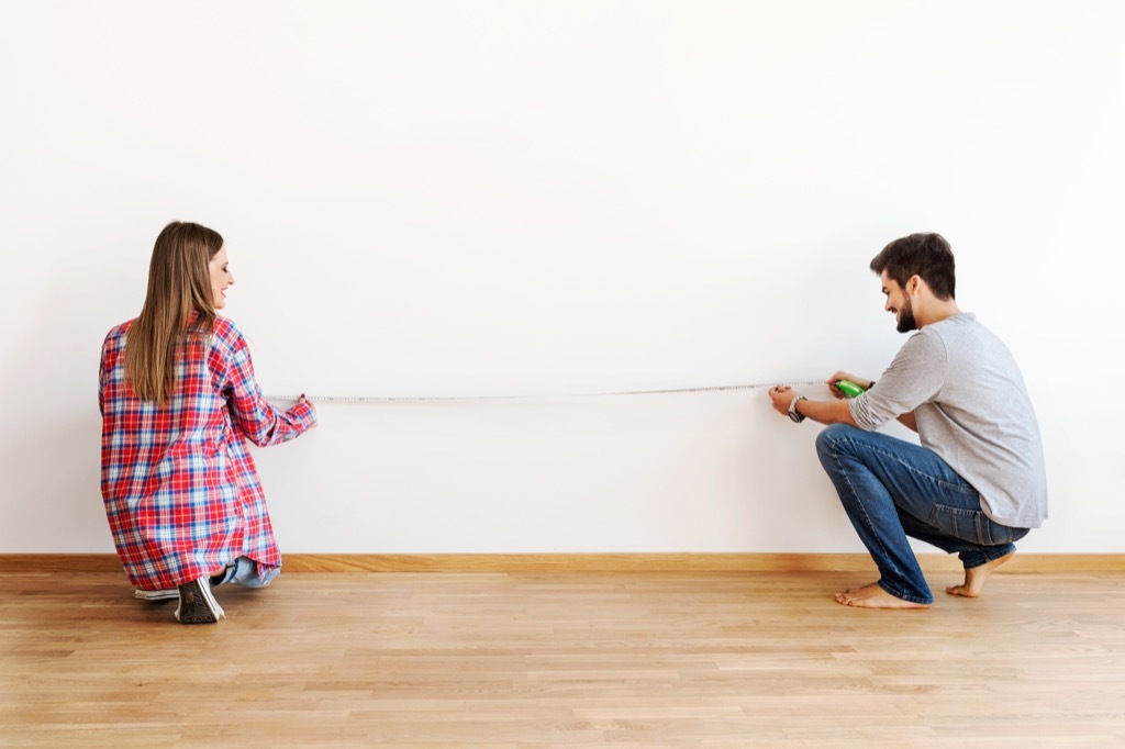 Couple Using a Tape Measure in an Empty Apartment {Ikea Shopping Tips}