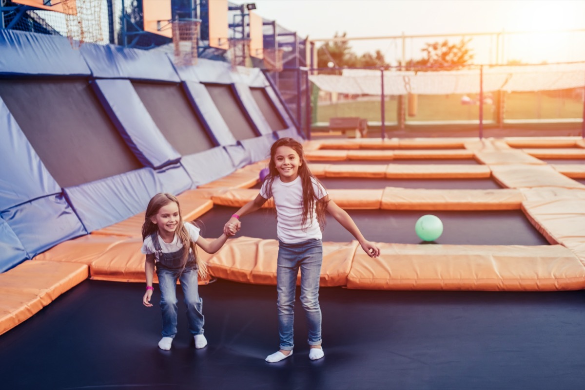 Two little girls jumping on trampoline