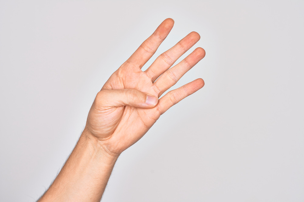 A close up of a hand with a the thumb stretched across the palm