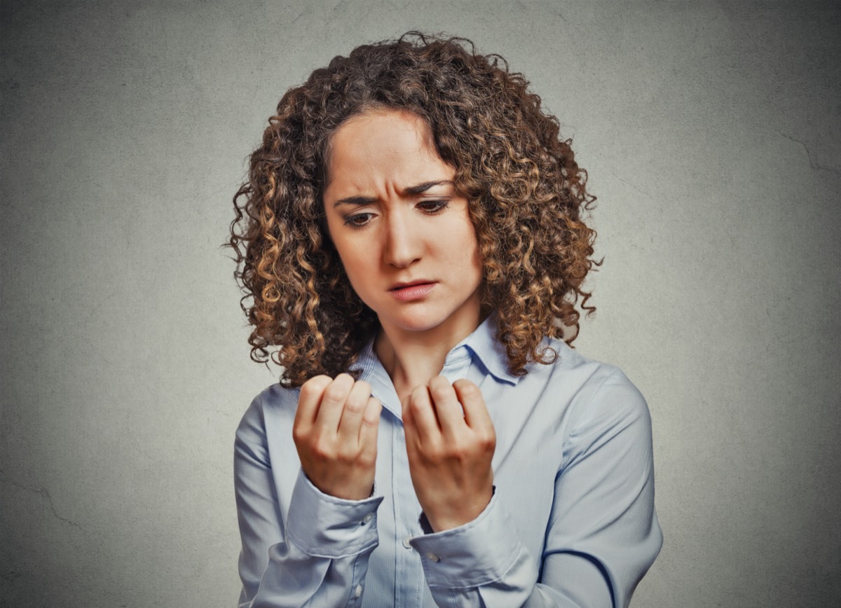 worried woman looking at hands fingers