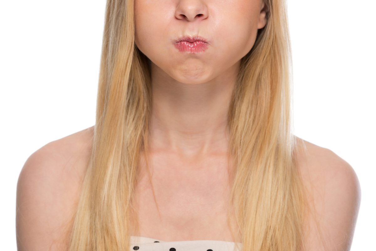 young woman shown from the nose down holding her breath