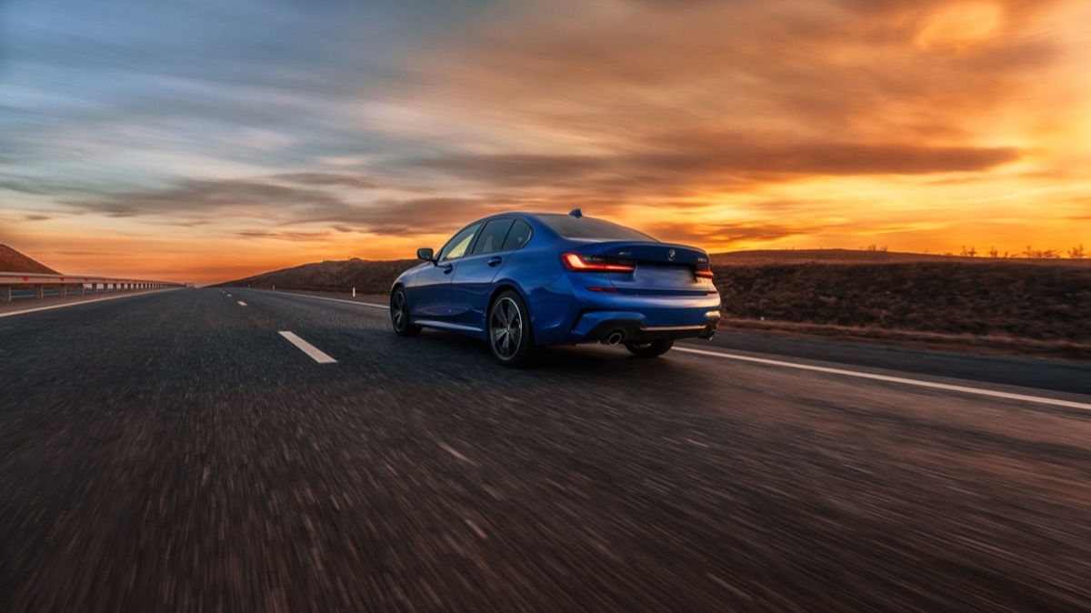 blue car driving fast on the road