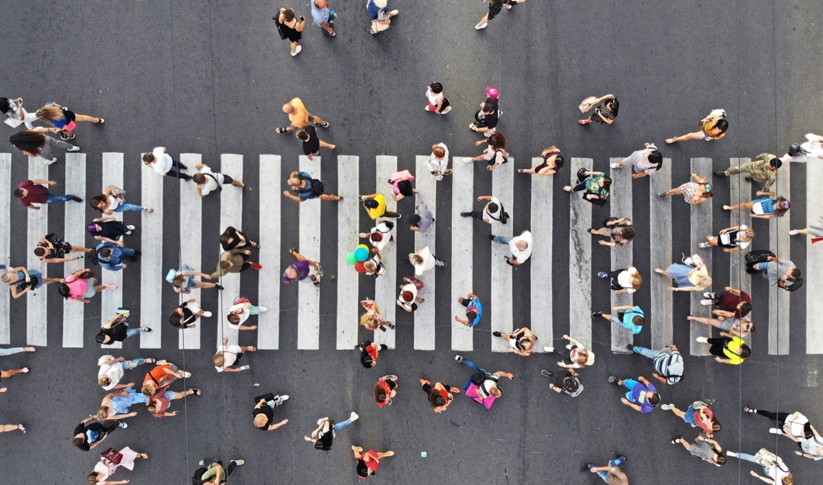 Crowd of people crossing at crosswalk in street