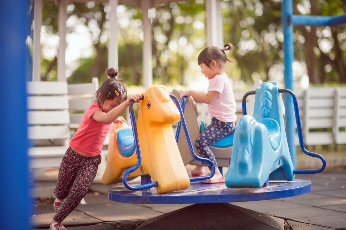 two young asian girls playing on playground