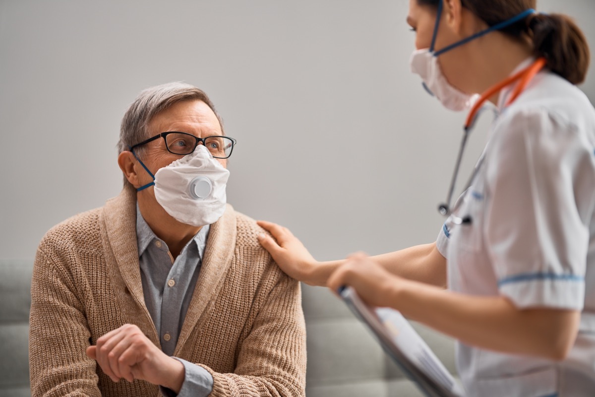 Doctor and senior man wearing facemasks during coronavirus and flu outbreak. Virus and illness protection, home quarantine. COVID-2019