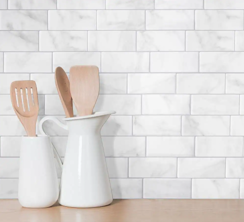 Close up of a backsplash with Home Depot's peel-and-stick faux-marble subway tiles.