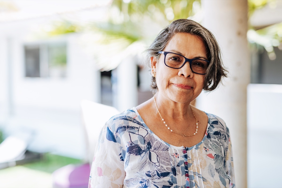 older latino woman looking at the camera with a soft smile