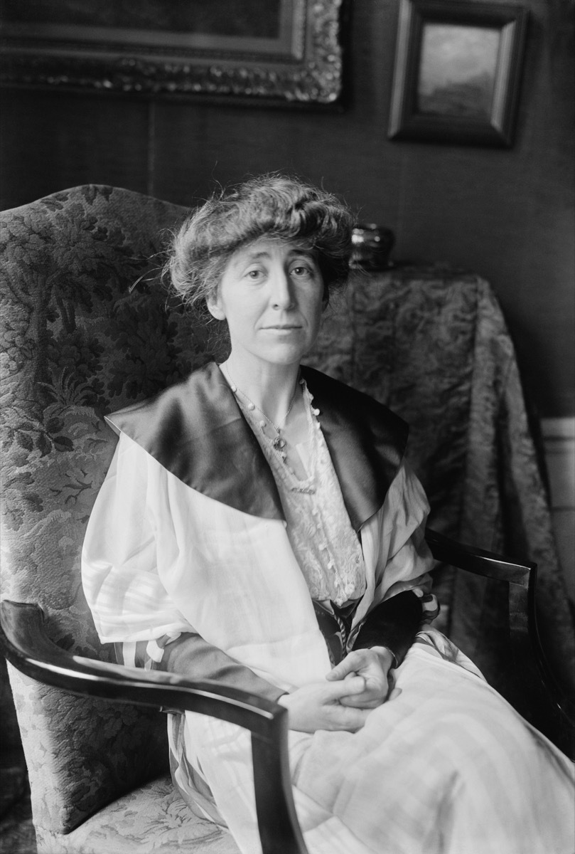 black and white photo of Jeannette Pickering Rankin sitting in a damask chair with wooden handles, state fact about Montana