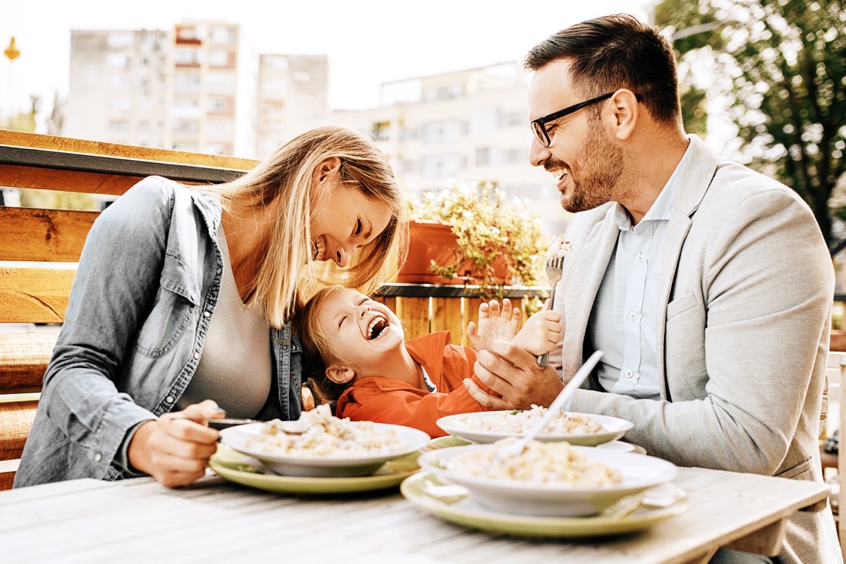 Happy family is enjoying pasta in restaurant.