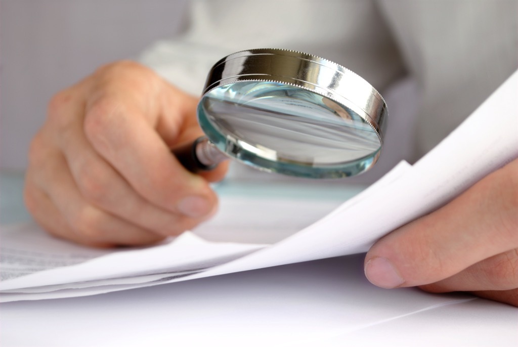 Man using a magnifying glass to read something