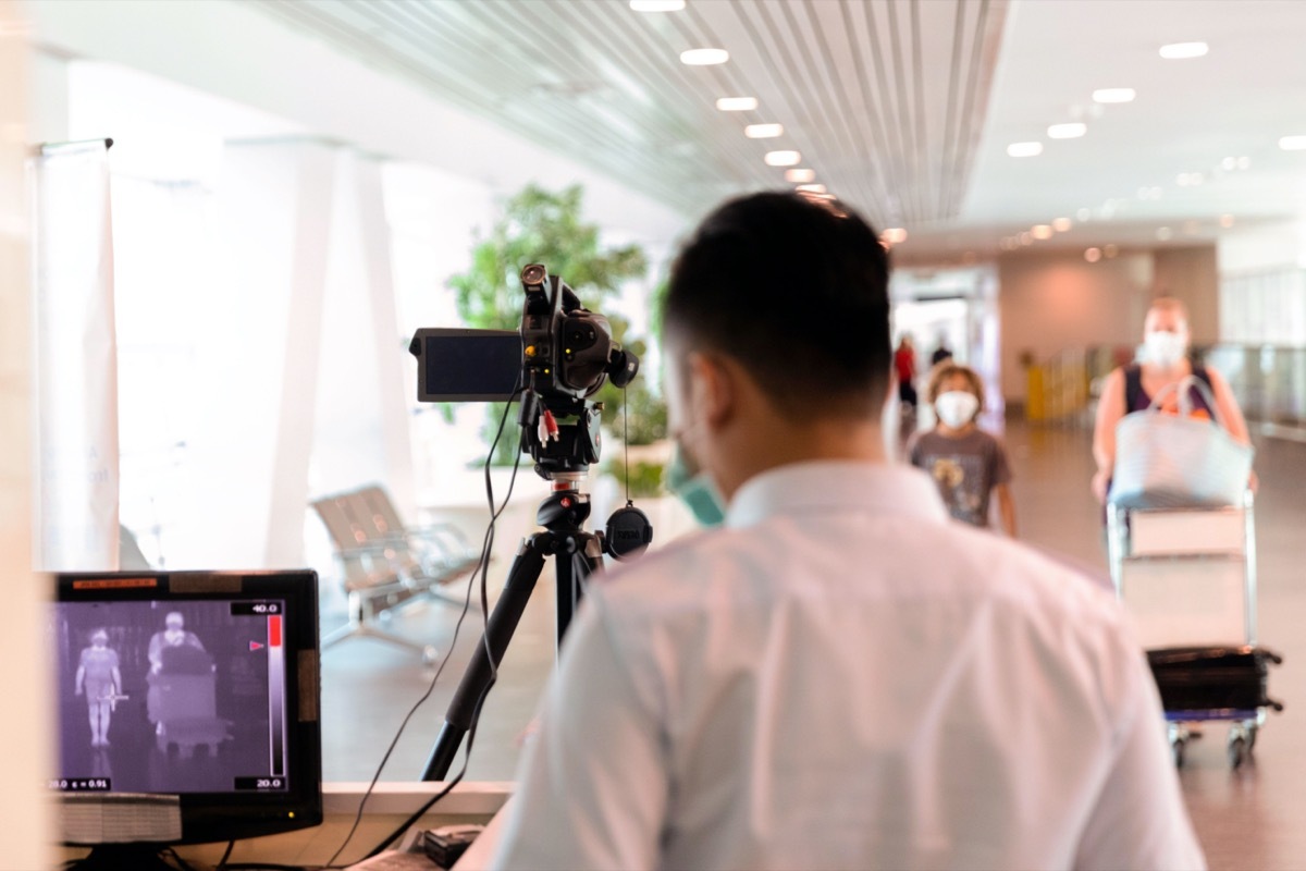 Airport medical staff detect incoming passengers body temperature with thermal camera