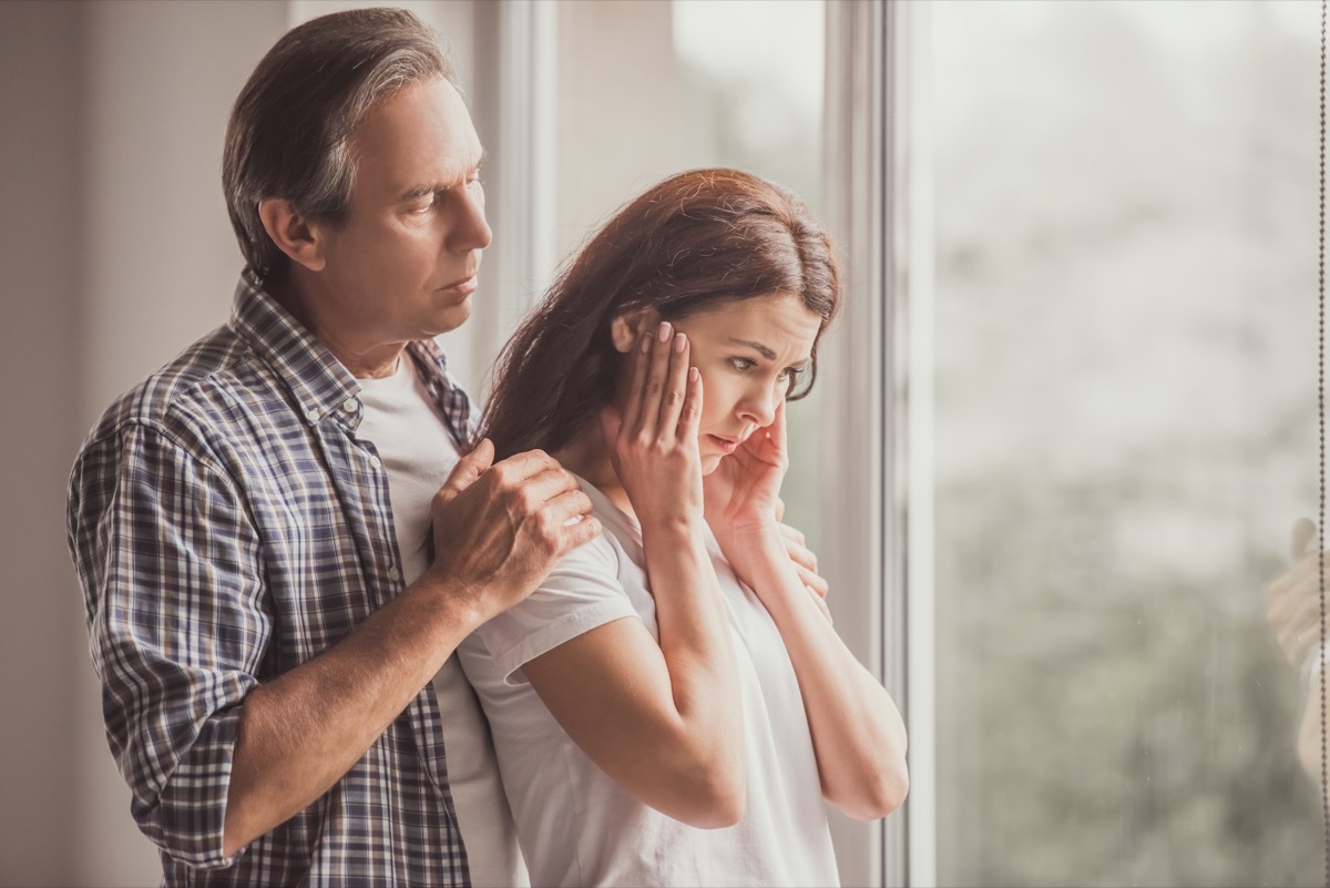 A woman is upset as her partner holds her looking concerned. 