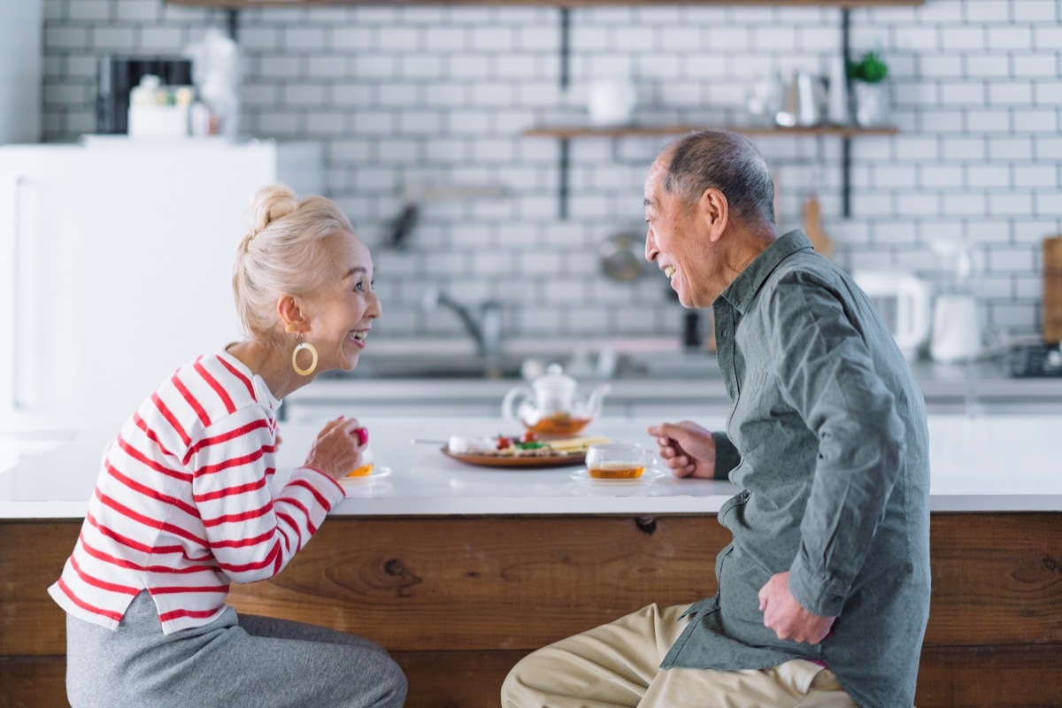 an older couple making eye contact with each other in their kitchen