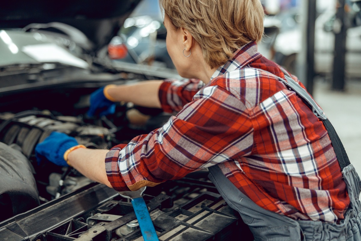 Mature woman working on car