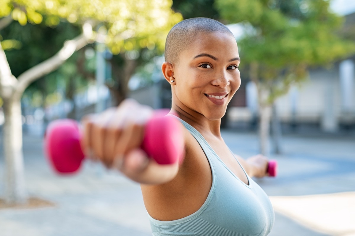 Portrait of happy woman exercising while looking at camera. 