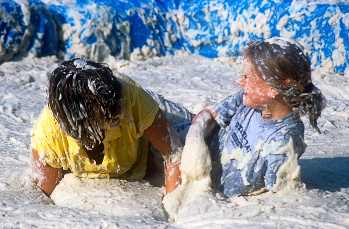 people competing in a mashed potato wrestling contest