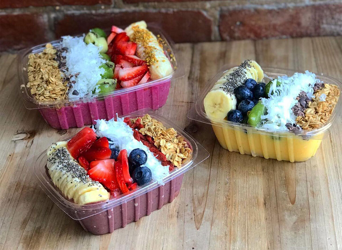 three acai bowls topped with fresh fruit