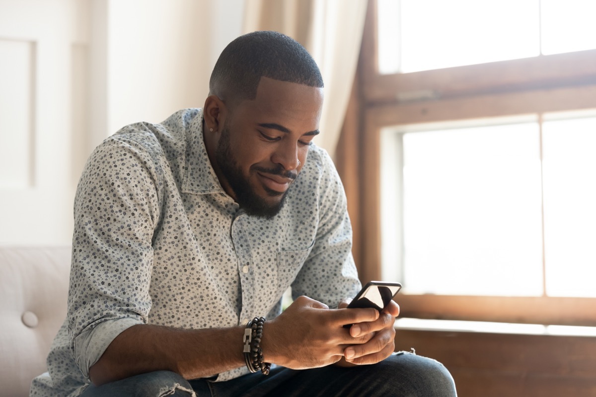 man holding smartphone texting message or play mobile game