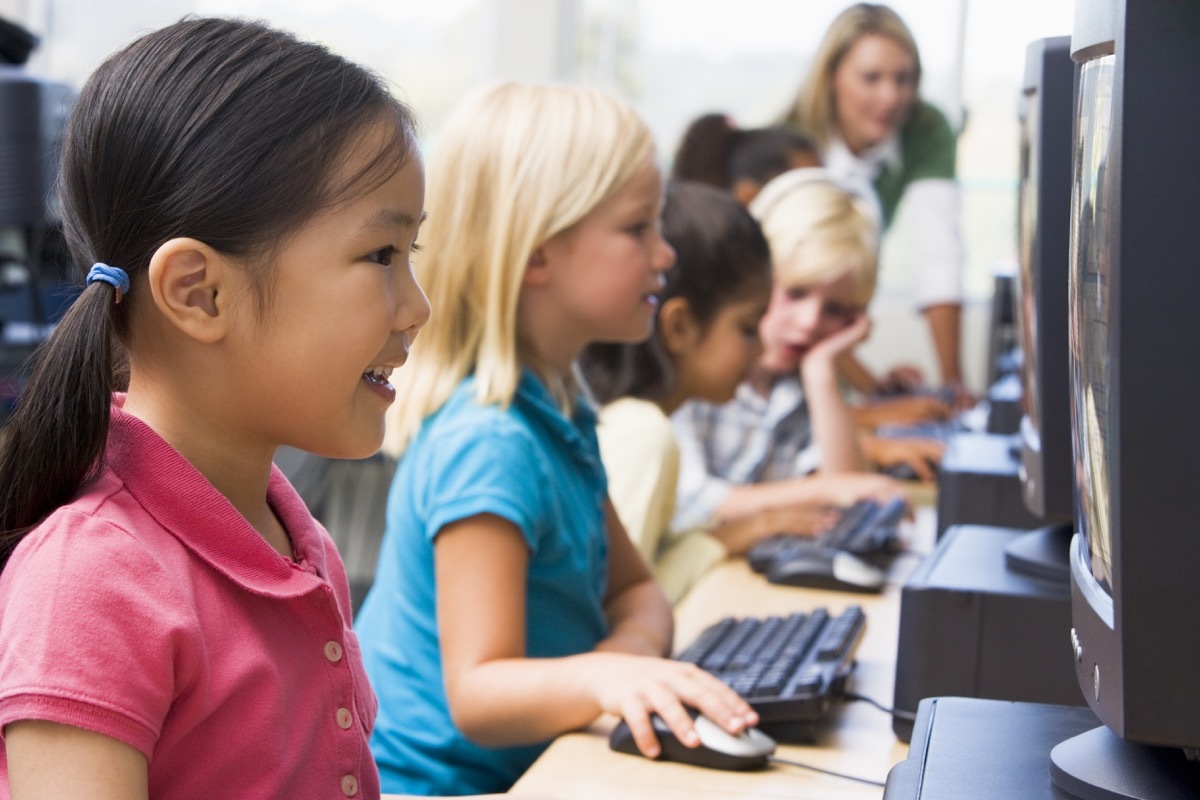 elementary school children in a computer lab with old technology