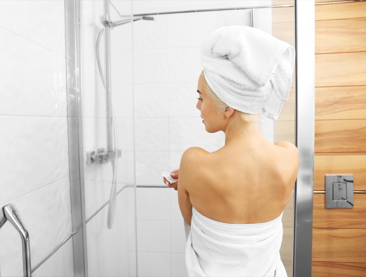 young woman stepping into shower