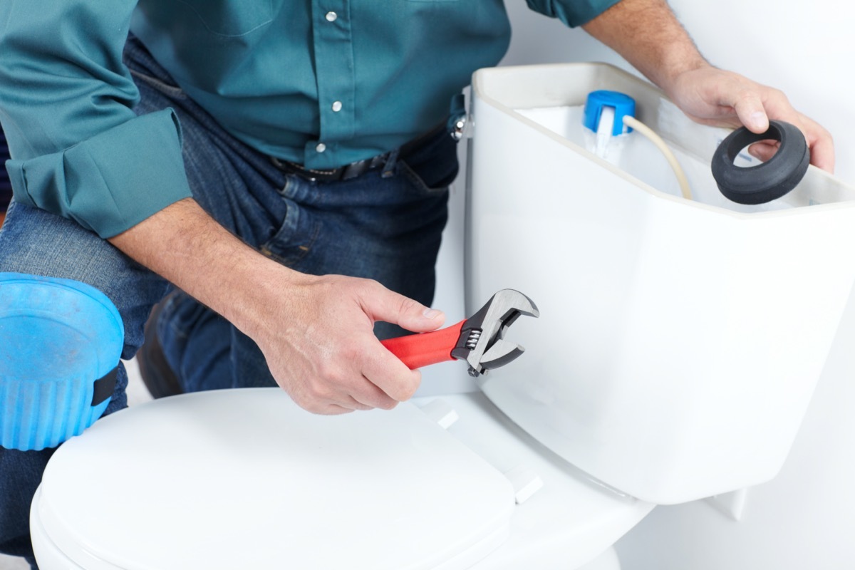 Plumber with a toilet plunger. The worker