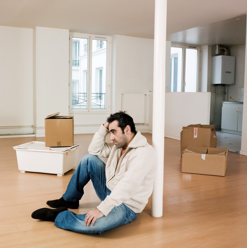 man alone in empty apartment because of divorce preparation 