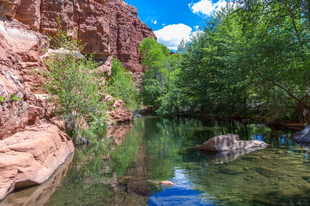 natural swimming hole with sandstone cliff on the left