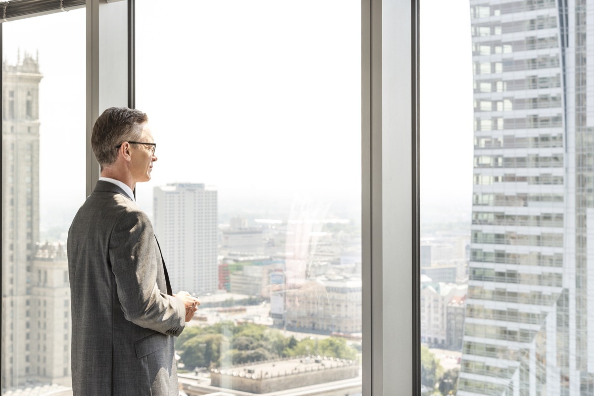 man looking out the office window